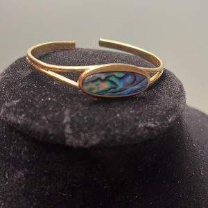 Br21. Gold colored bracelet with iridescent stone.